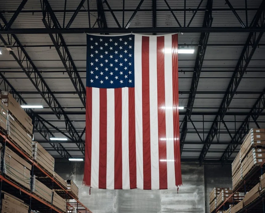 American flag hanging above stocked warehouse aisles